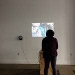 A person looking at a video being projected onto the wall
