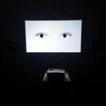 An illustration of a pair of eyes being projected onto the wall