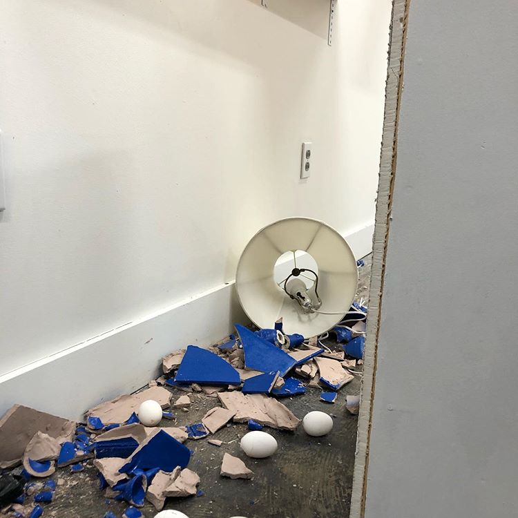 Blue and white items on the floor arranged to look like rubble