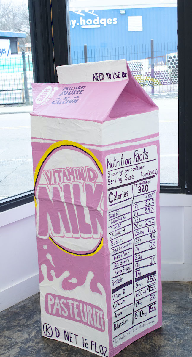 A photo of a link and white half-gallon carton of milk