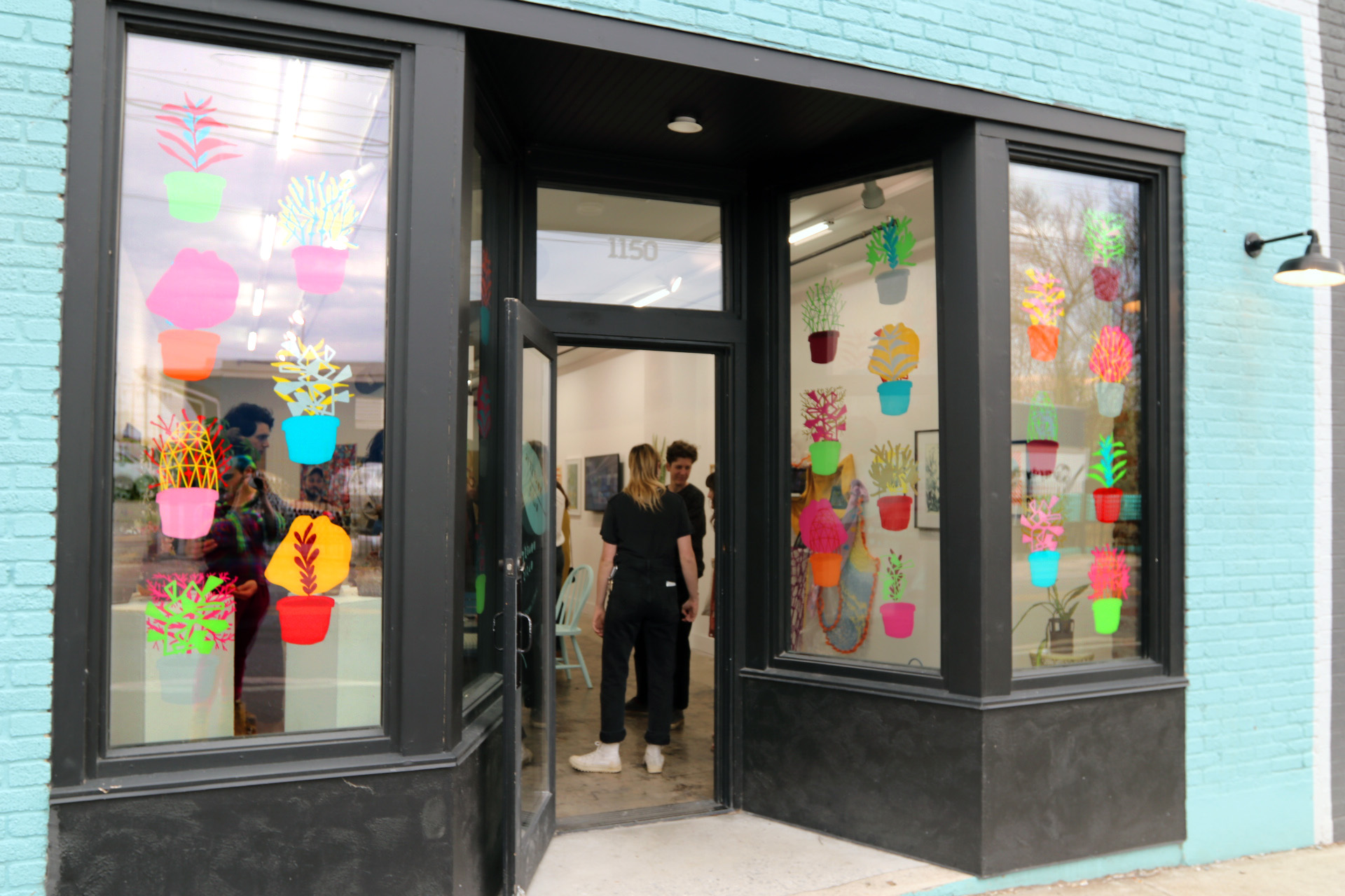 The front of the gallery decorated with vinyl stickers of plants