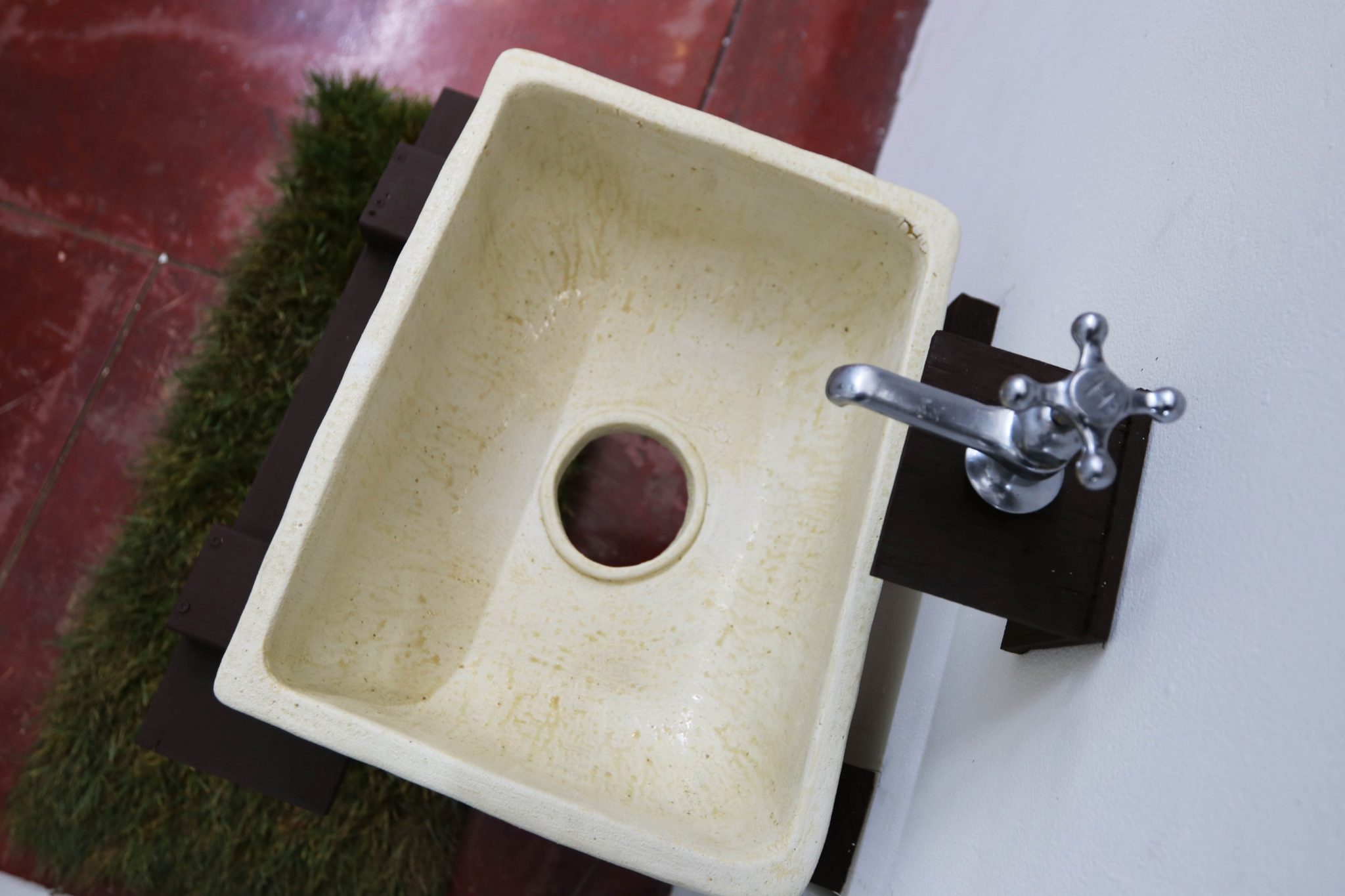 A photo of art from "Age Ingrained" showing an overhead view of a bathroom faucet and sink