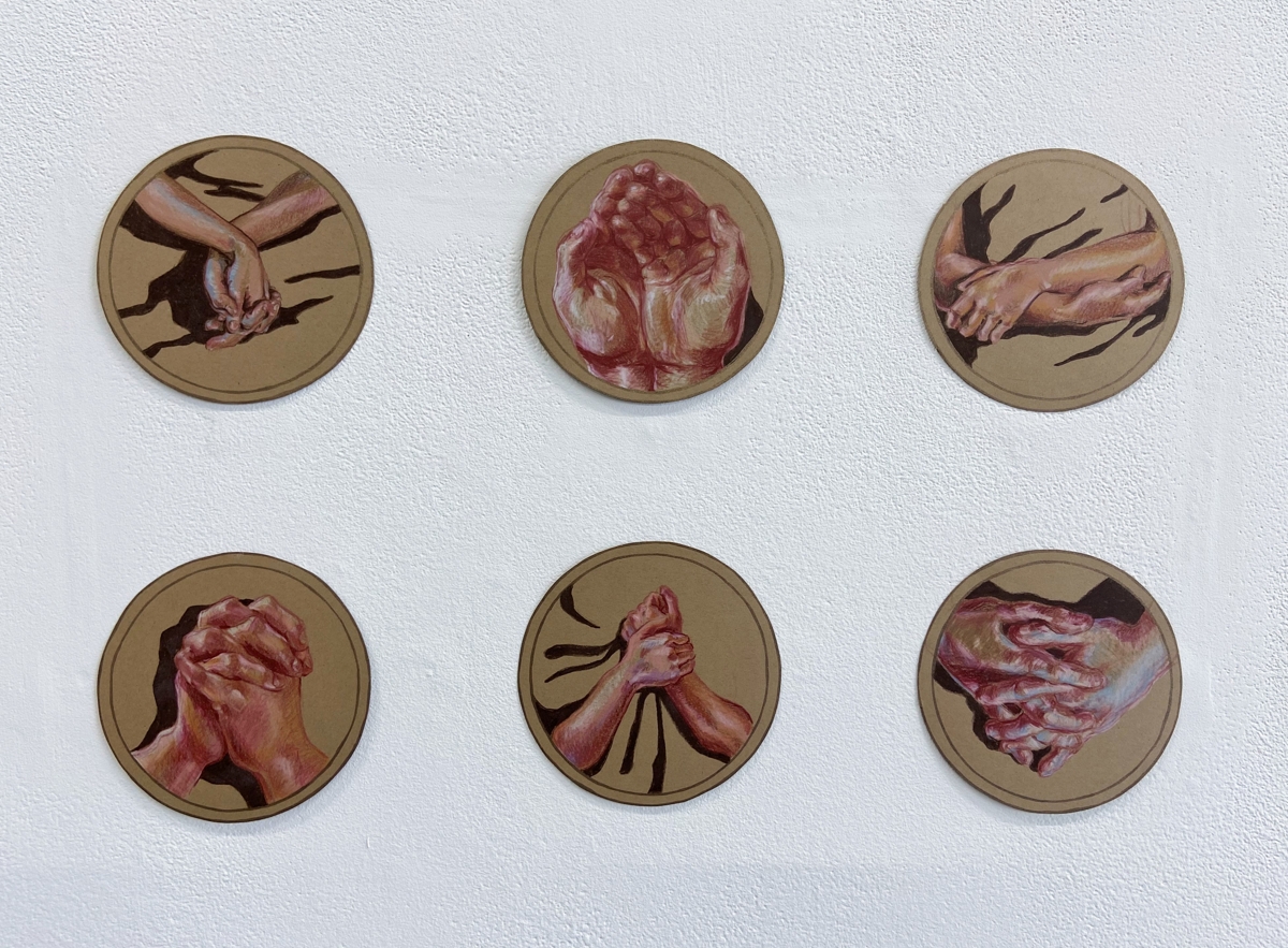 Medallion-style shapes with paintings of hands in various positions