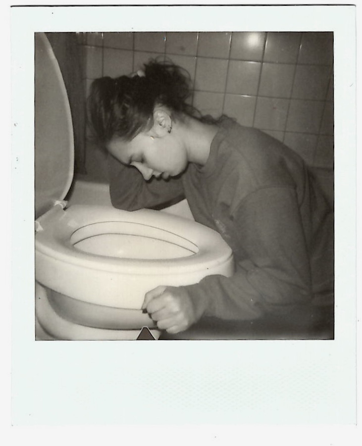 A young woman leaning over a toilet