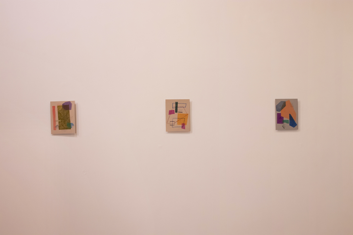 A zoomed out photo of the installation at the gallery, abstract paintings framed on the walls
