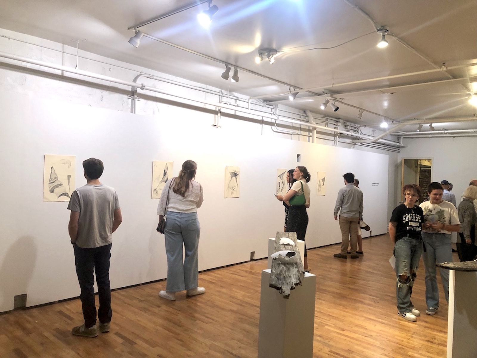 Patrons looking at the printmaking artworks on the wall