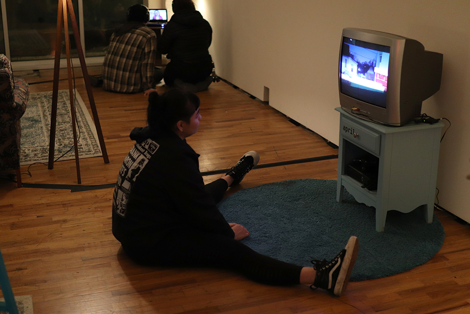 A woman sitting on the floor watching a video on a small tv