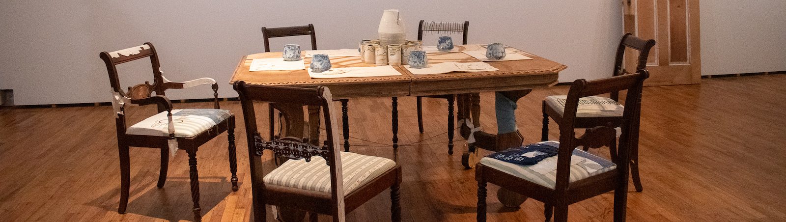 A photo of a dinner table set up at the gallery surrounded by chairs