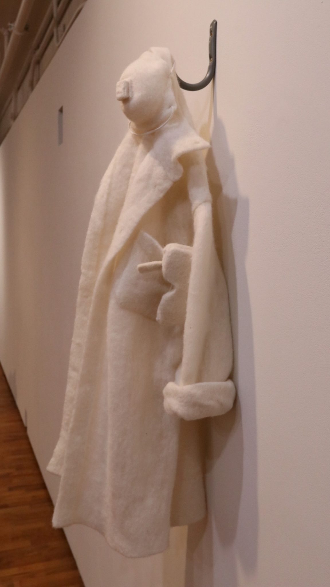 A white cloth in the shape of a person hanging from a hook