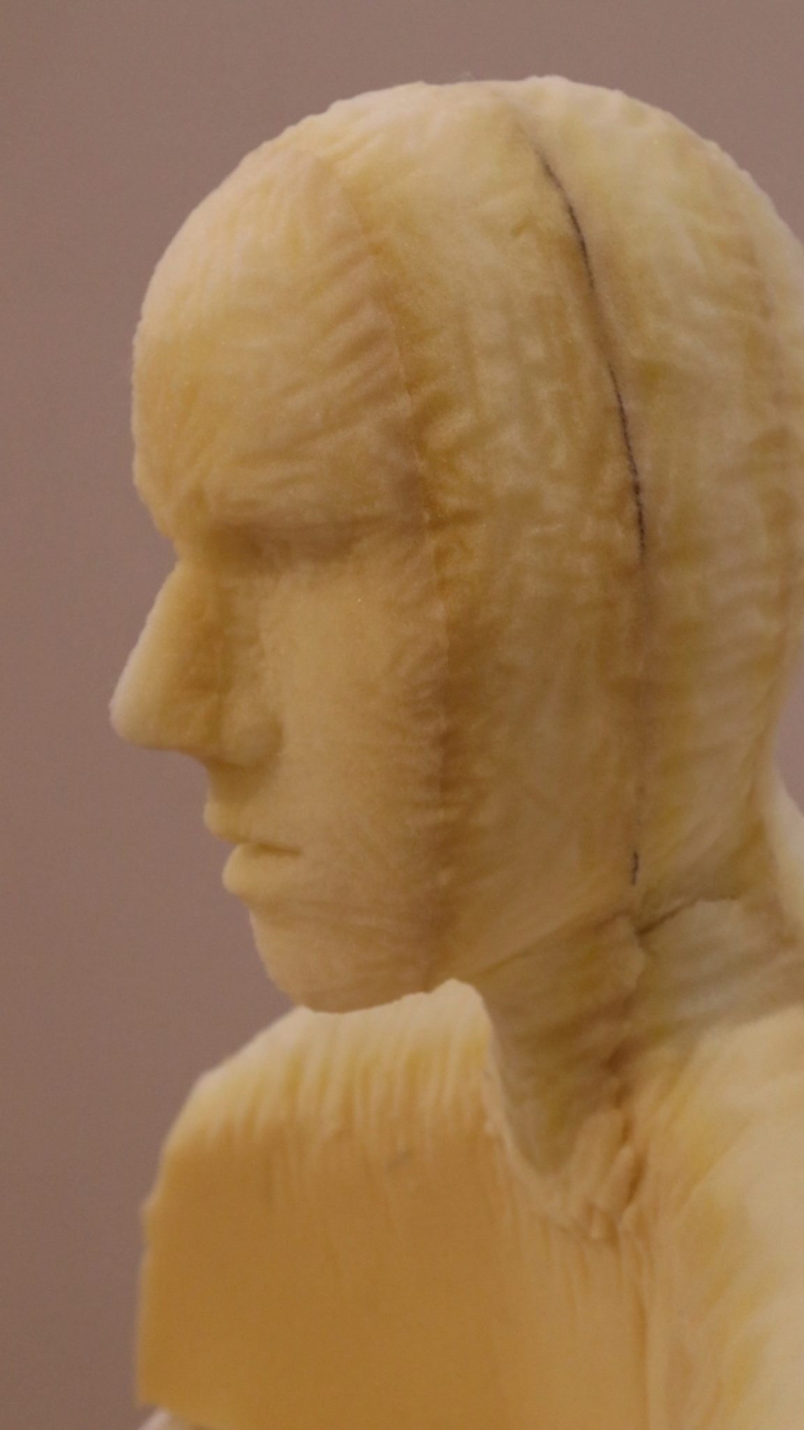 A yellow sculpture of a human profile