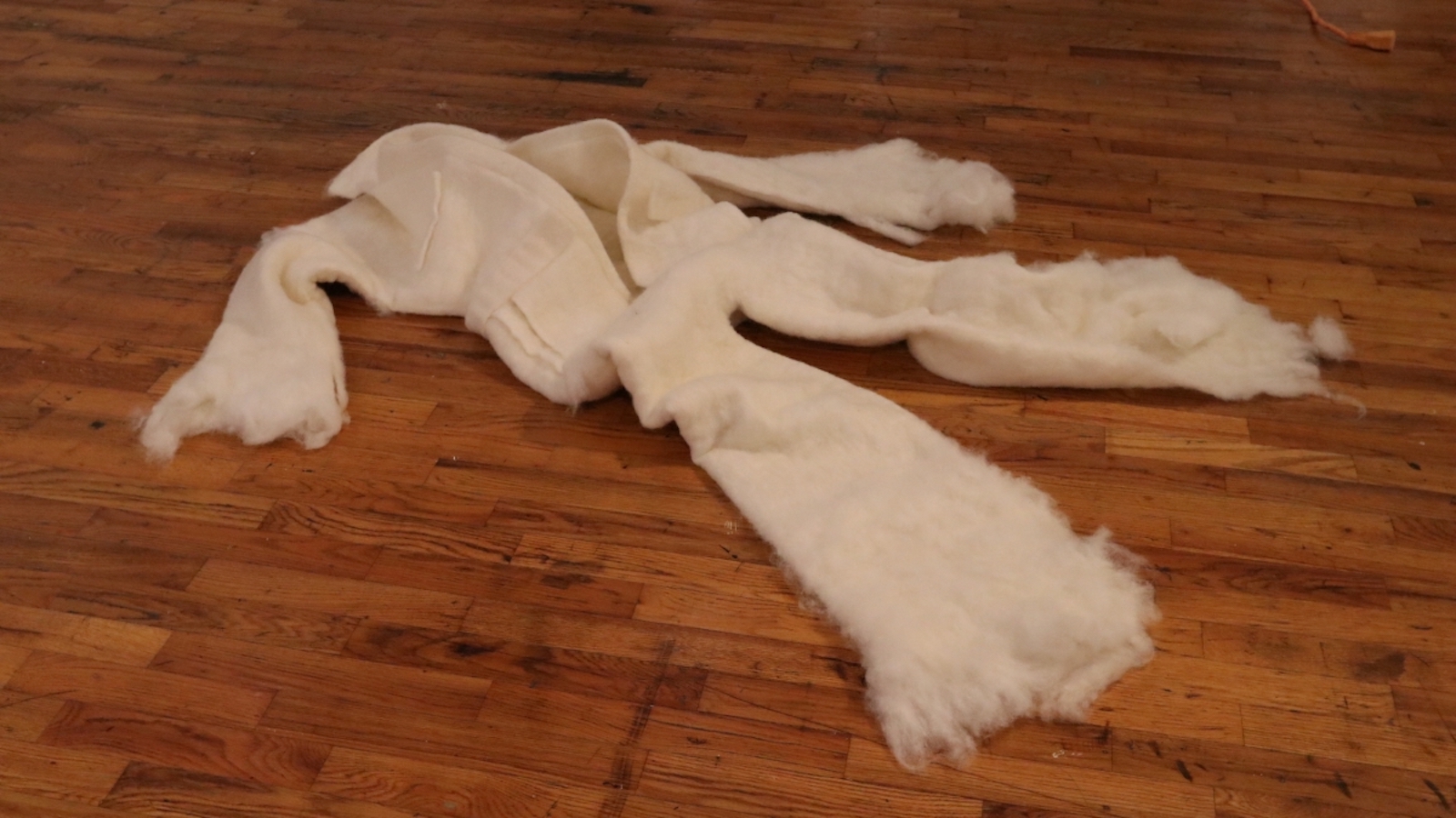 White cloth on the floor with frayed ends