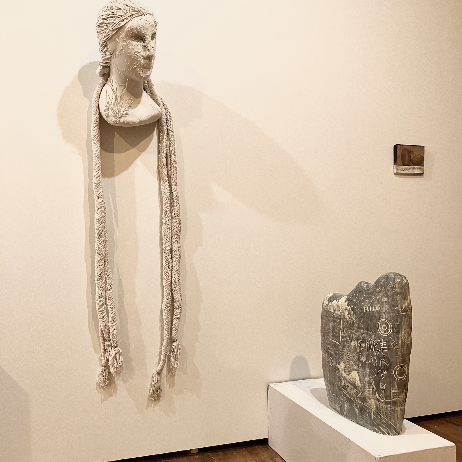 A bust of a woman on the wall with hair drooping down almost to the floor