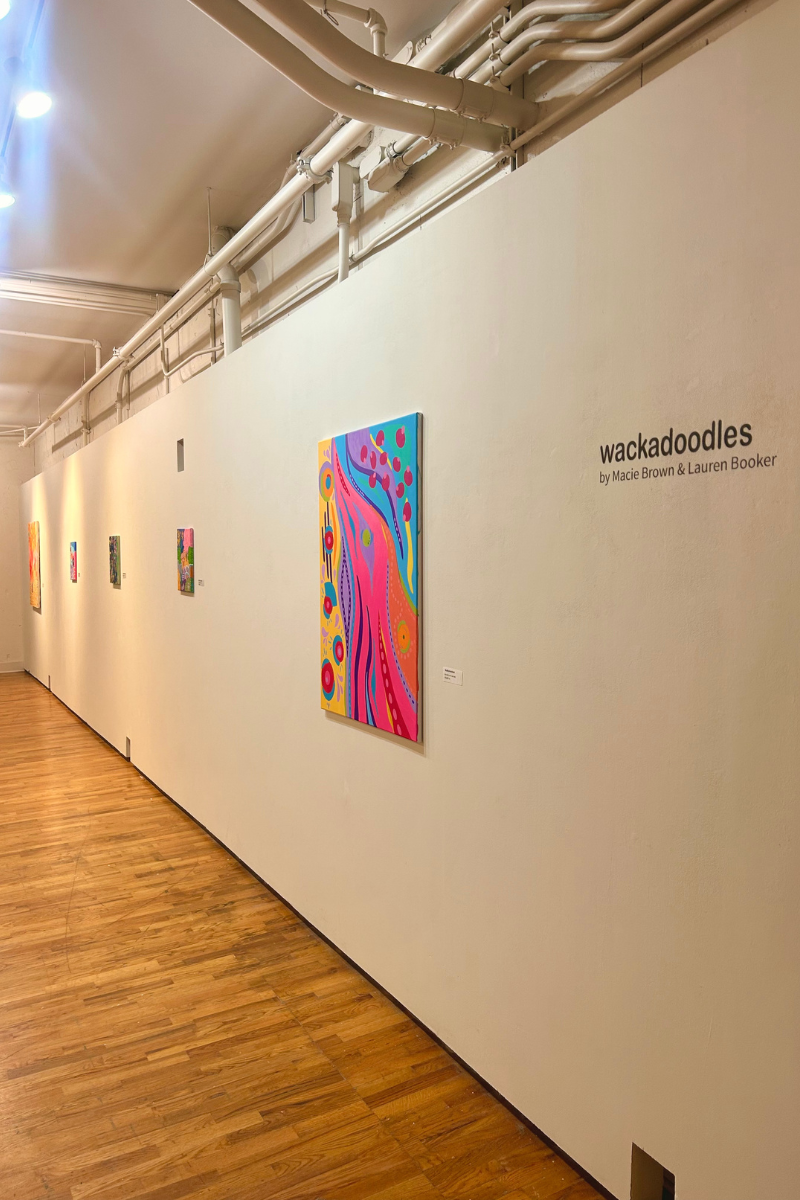 Gallery wall with exhibition title and five paintings.