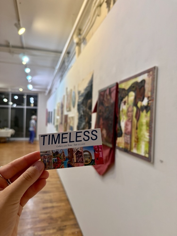Hand holding a promotional show card with the title Timeless.
