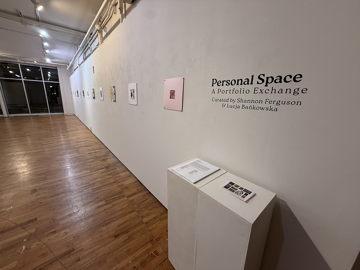 Gallery with printed works on paper and wall vinyl with the show title.
